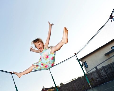 Girl jumping on trampoline.