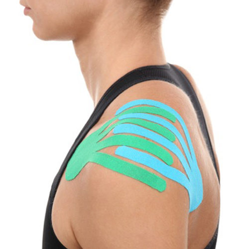 Blue and green kinesiology tape on a woman's shoulder.