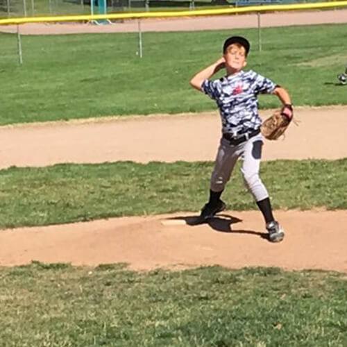 Little boy throwing baseball.