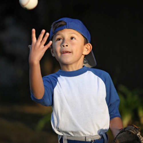 little boy catching baseball.