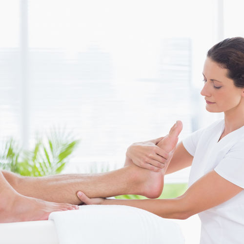 Photo of a woman massaging a foot.