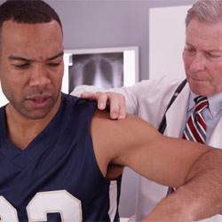 A doctor examining a man's shoulder.