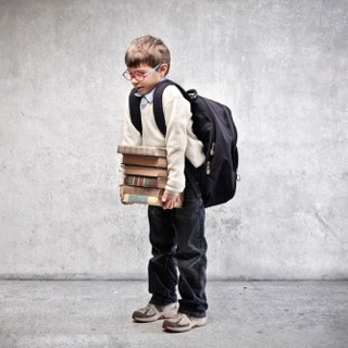 Photo of a small child holding a pile of books.