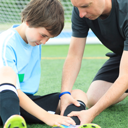 A coach helping an injured soccer player.