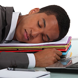 Man sleeping on a pile of books.