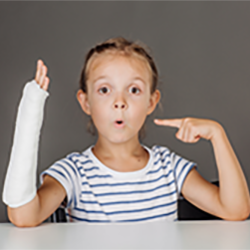 little girl pointing at her cast.