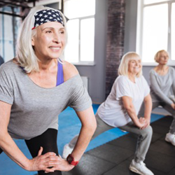 Older woman stretching alongside other older women.