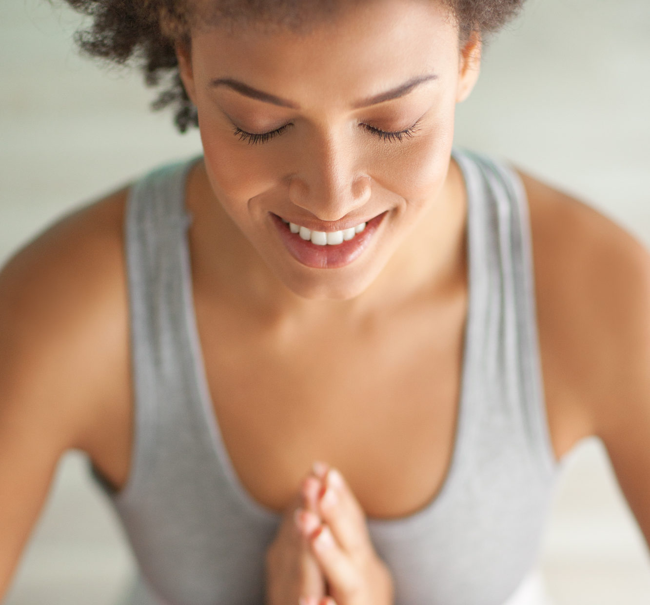 Indoor shot of a young African woman doing yoga.