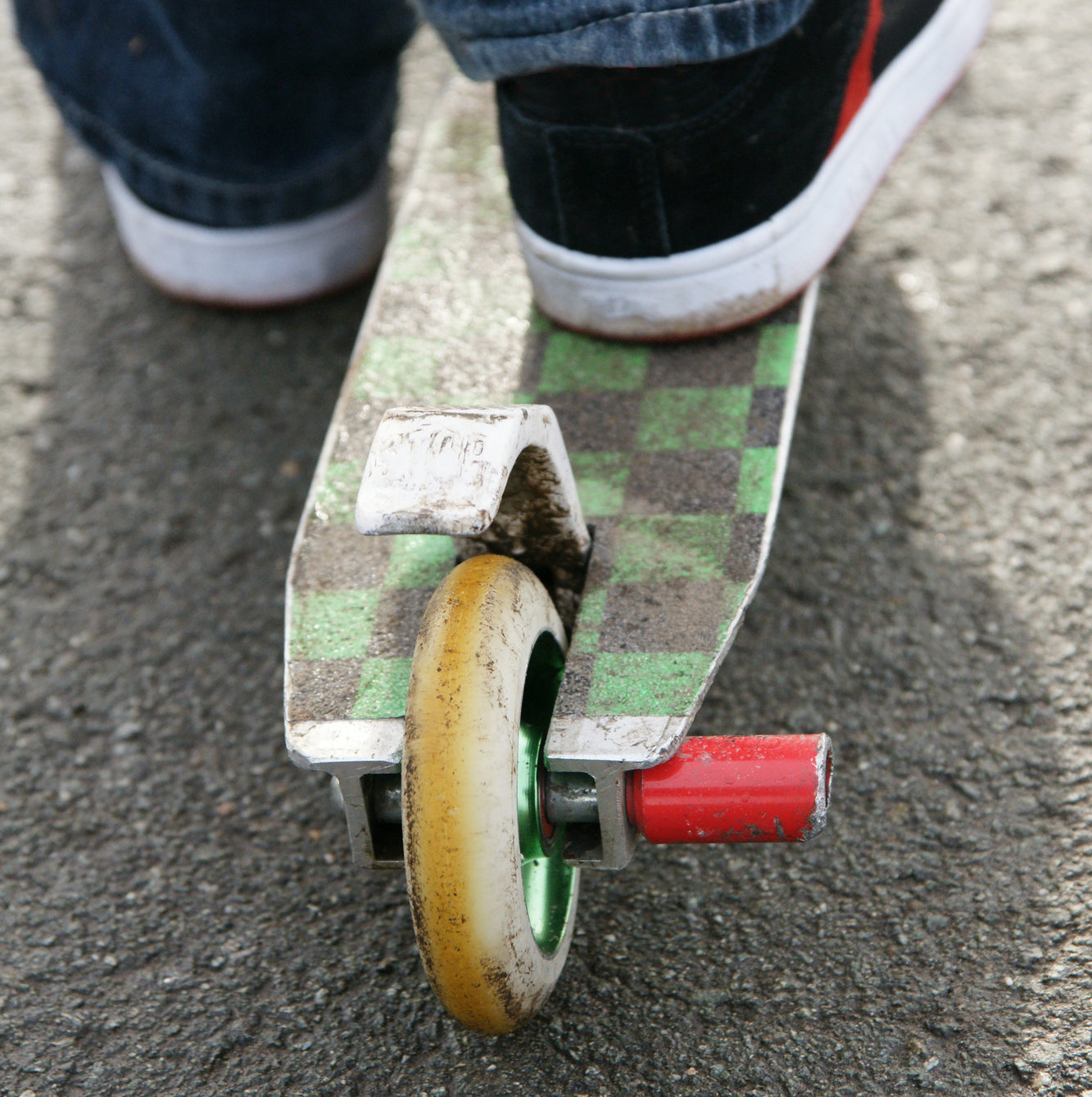A view of a well worn scooter used for stunt riding.