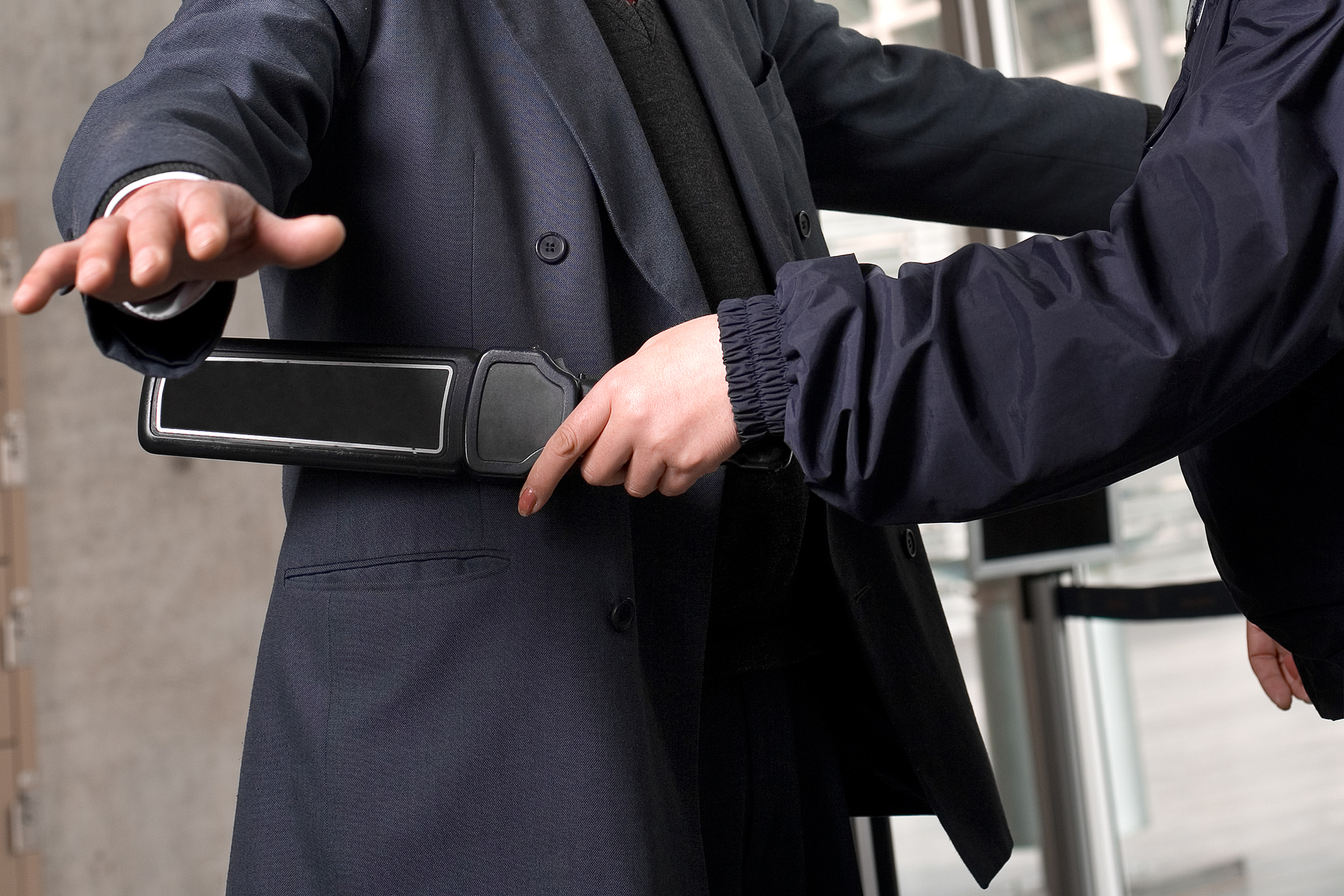 Man being checked by airport security metal detector.