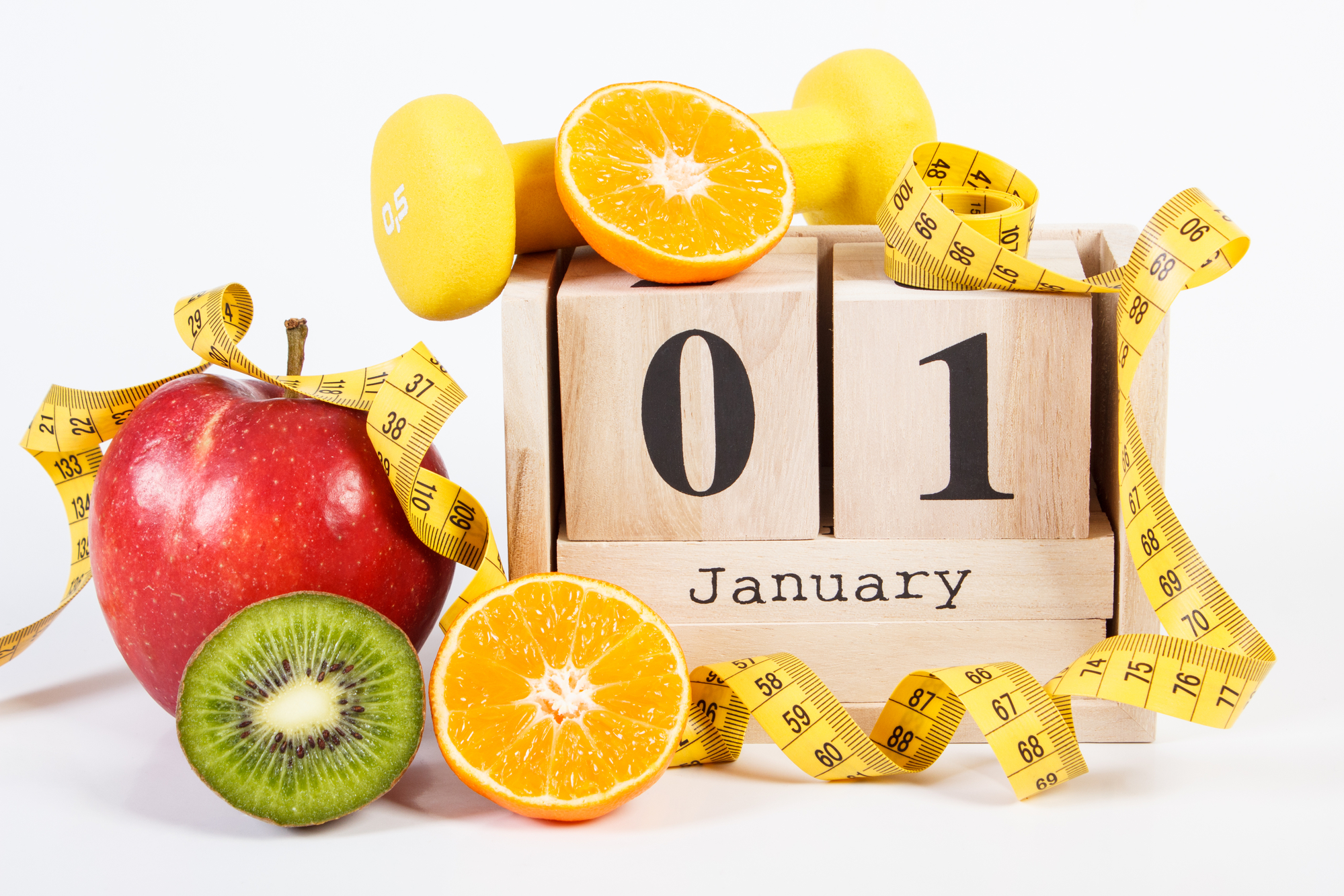 January 1 on cube calendar, fresh fruits, dumbbells and tape measure, new years resolutions of healthy lifestyle.