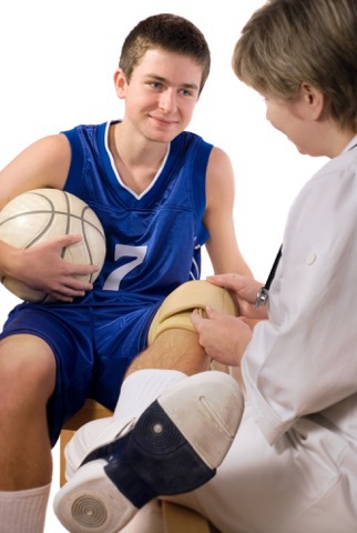 Stock image of doctor examining a basketball player's knee.