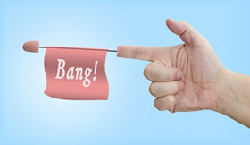 Photoshopped hand with index finger pointing like a gun with a flag labelled 'Bang!' extending from the index finger.