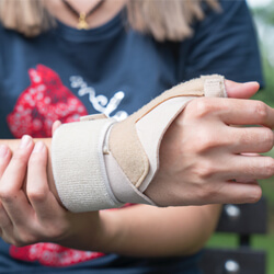 Close up shot of woman holding her wrist in a splint.