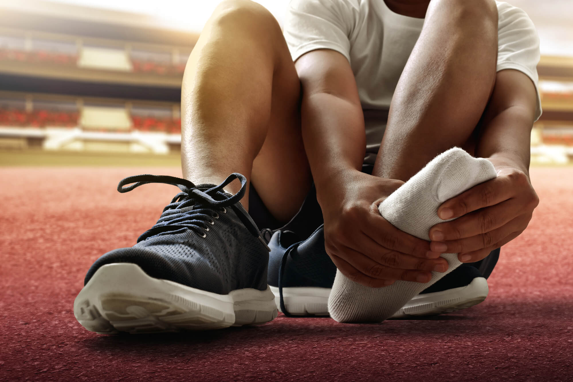 Runner examining painful area in his foot.