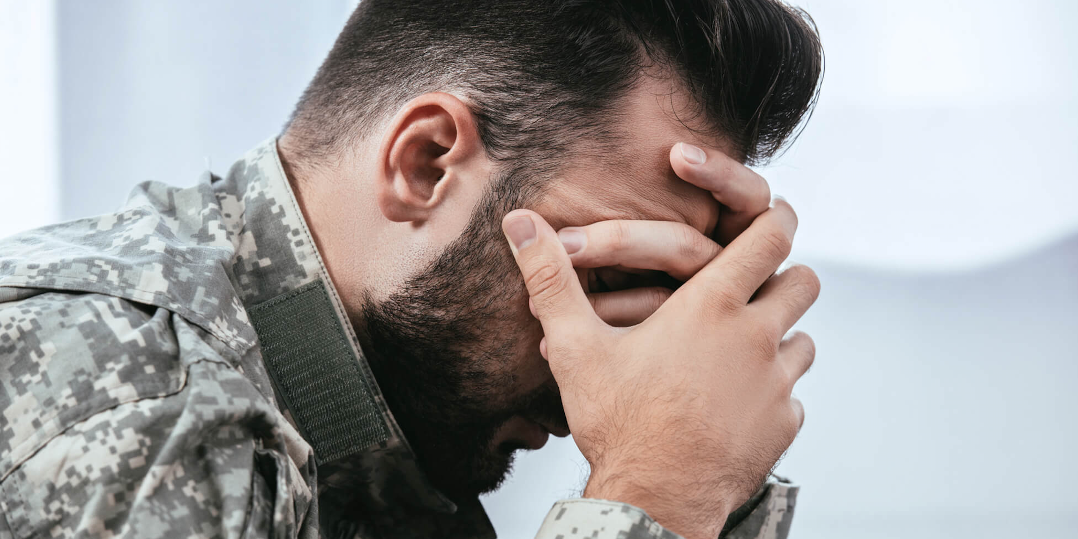 Depressed man in army uniform.