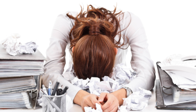 Stressed woman at her cluttered desk at her office