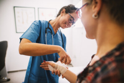 Nurse wrapping a patient's wrist with tape