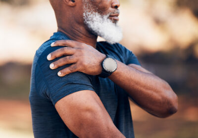 Middle aged man grabbing his shoulder in pain